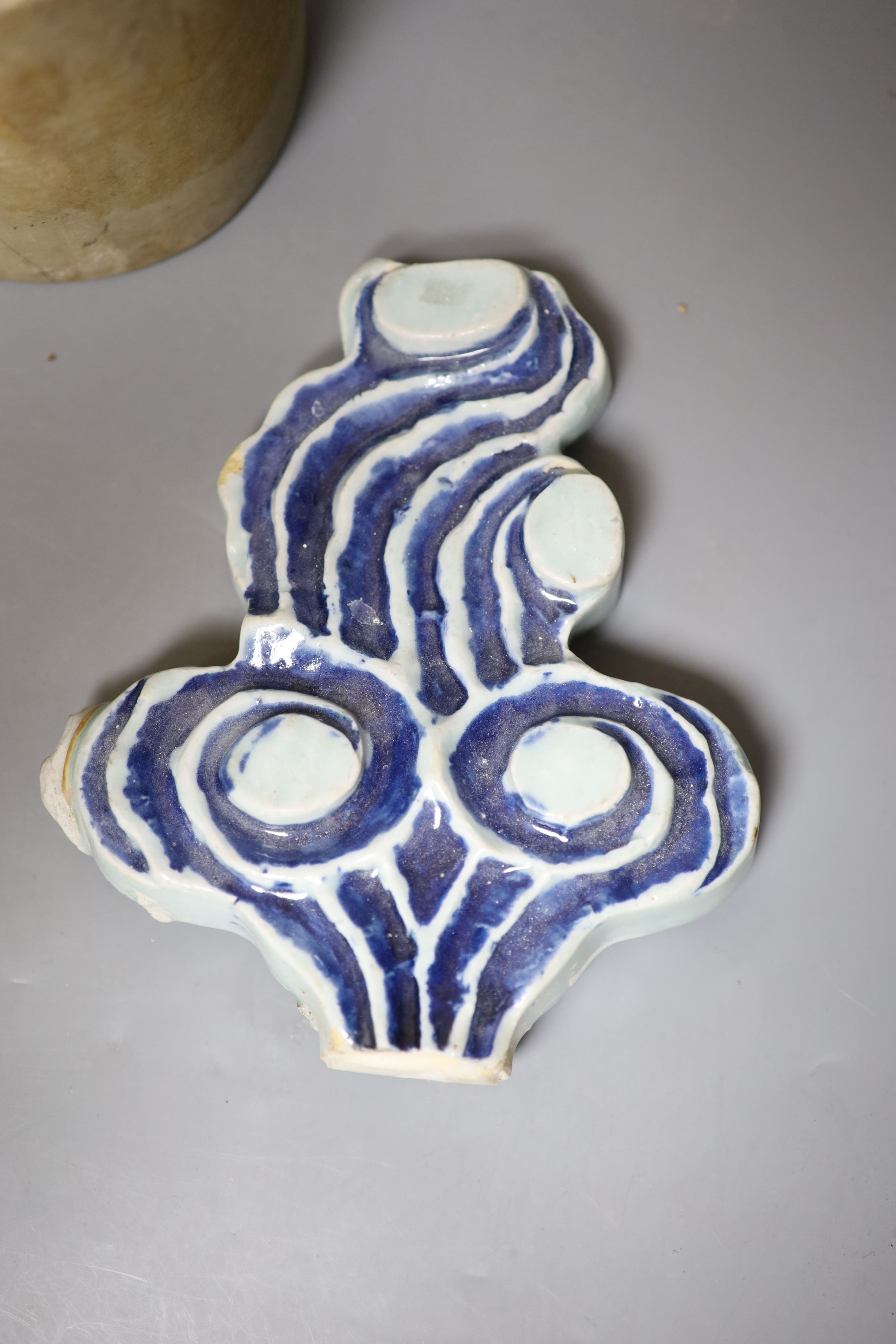 A Chinese blue and white Ming porcelain finial, a leather wallet. c.1920 and a cream stone cylinder, longest 29cm